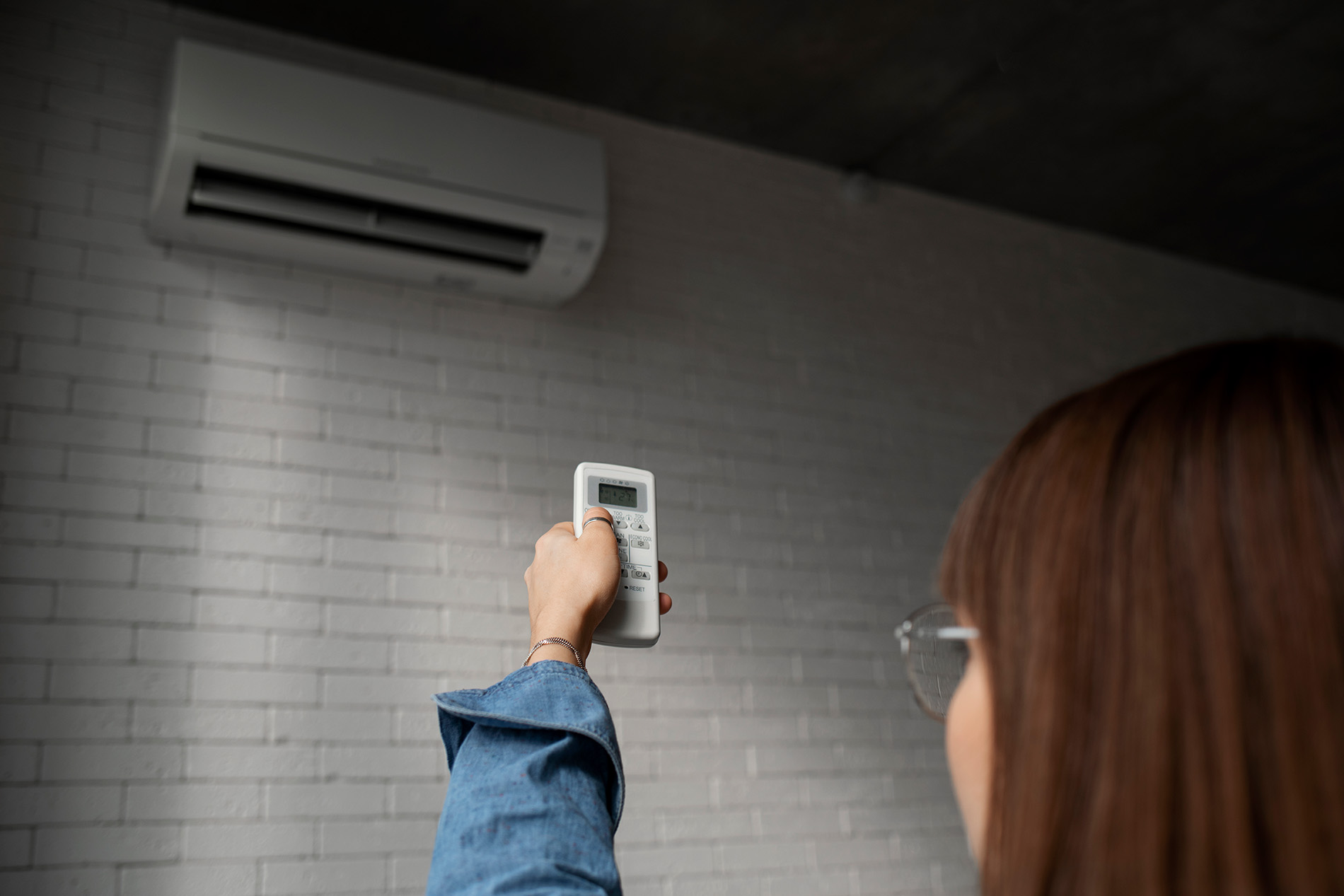 woman checking air conditioning unit